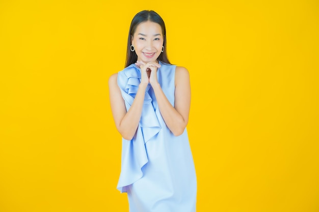 Portrait beautiful young asian woman smiling on yellow