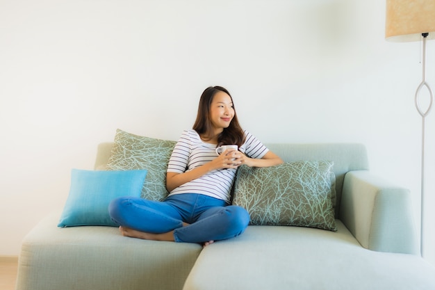 Portrait beautiful young asian woman on sofa with coffee cup