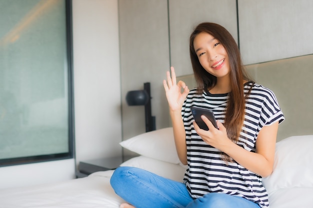 Portrait beautiful young asian woman use smart mobile phone in bedroom