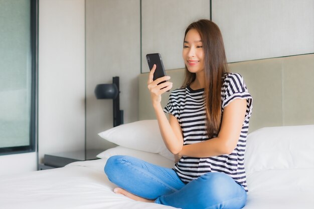 Portrait beautiful young asian woman use smart mobile phone in bedroom