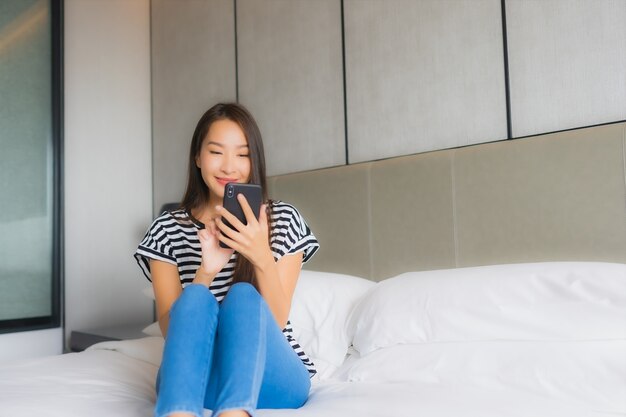 Portrait beautiful young asian woman use smart mobile phone in bedroom