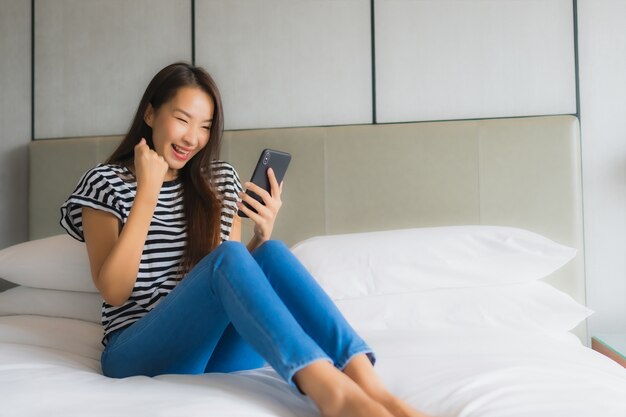 Portrait beautiful young asian woman use smart mobile phone in bedroom