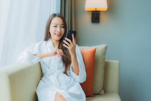 Portrait beautiful young asian woman use smart mobile phone on sofa