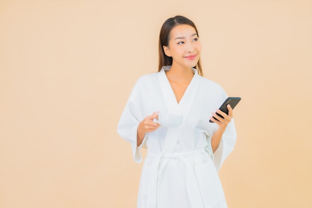 Portrait beautiful young asian woman using smart mobile phone on beige