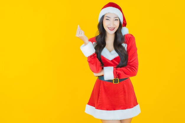 Portrait beautiful young asian woman wear christmas costume with action on yellow