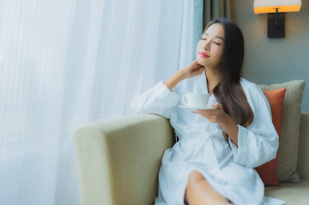 Portrait beautiful young asian woman with coffee cup on sofa