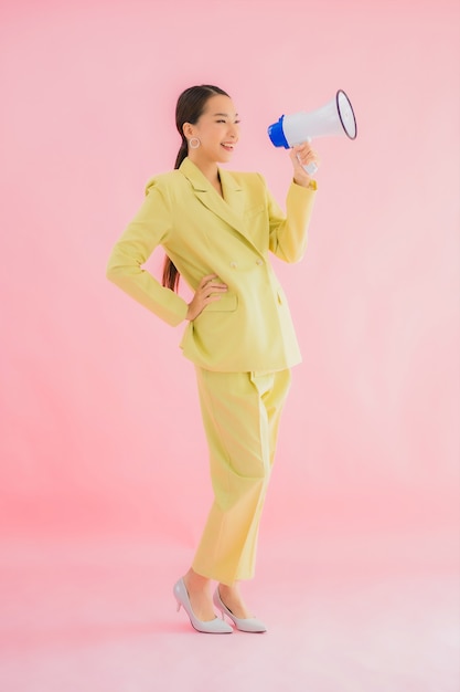 Portrait beautiful young asian woman with megaphone on color