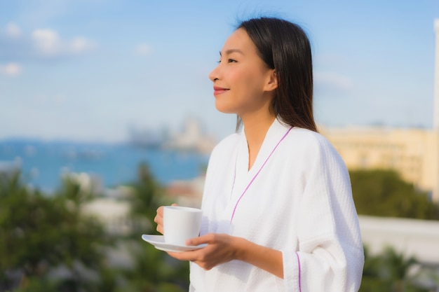 Portrait beautiful young asian women hold coffee cup in hand around outdoor view