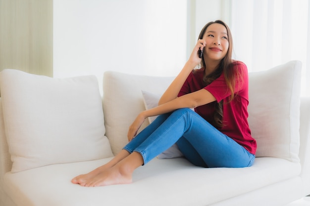 Portrait beautiful young asian women using mobile or smart phone on sofa