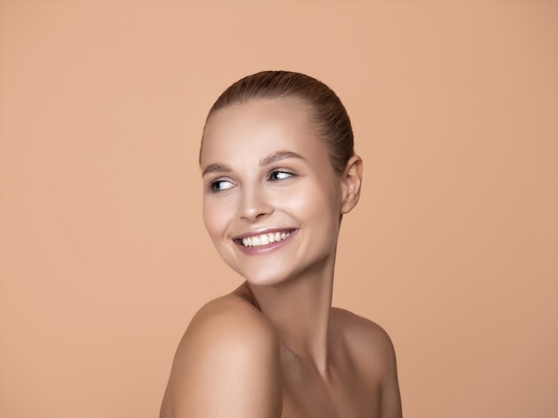 Free photo portrait of beautiful young woman on brown studio