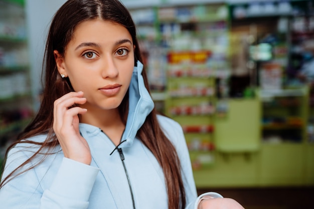 Free photo portrait of beautiful young woman at pharmacy