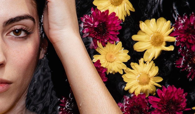 Free photo portrait of beautiful young woman posing with flowers