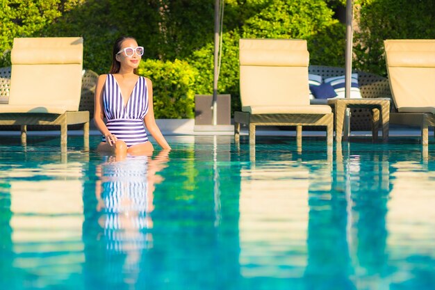 Portrait beautiful young woman relax smile leisure on vacation around swimming pool in resort hotel