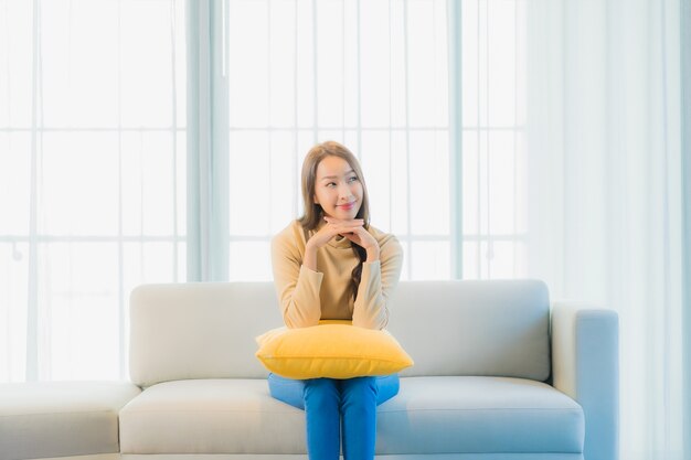 Portrait of beautiful young woman on sofa in living room