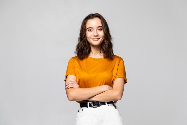 Portrait of beautiful young woman standing on grey wall