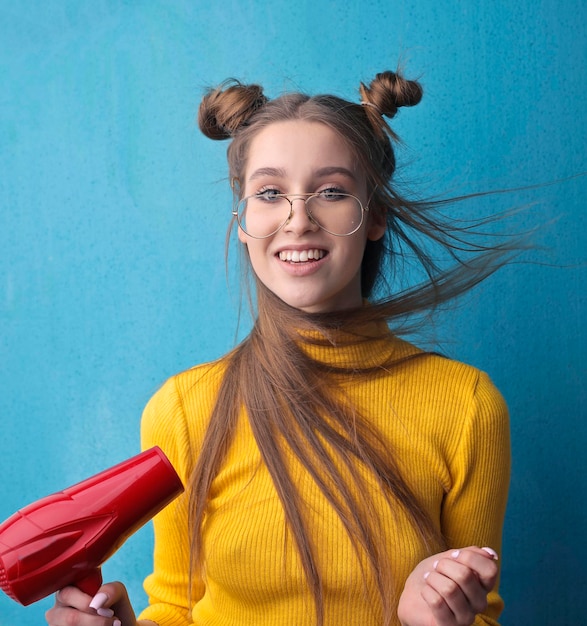 Free photo portrait of beautiful young woman while drying her hair