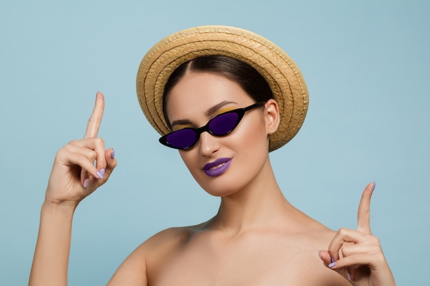 Free photo portrait of beautiful young woman with bright make-up isolated on blue studio