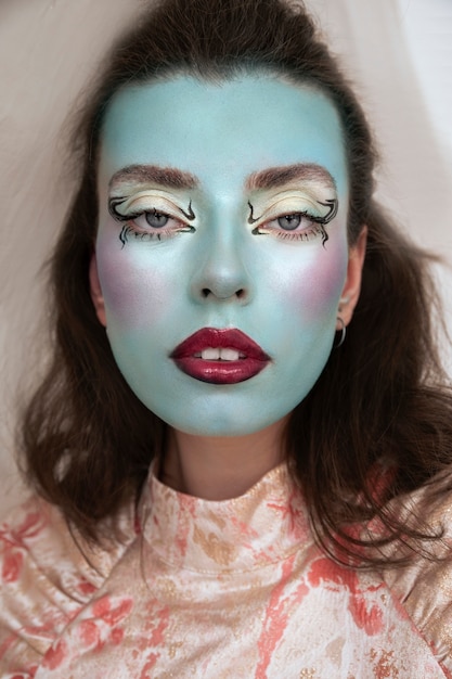 Portrait of beautiful young woman with colorful face make-up