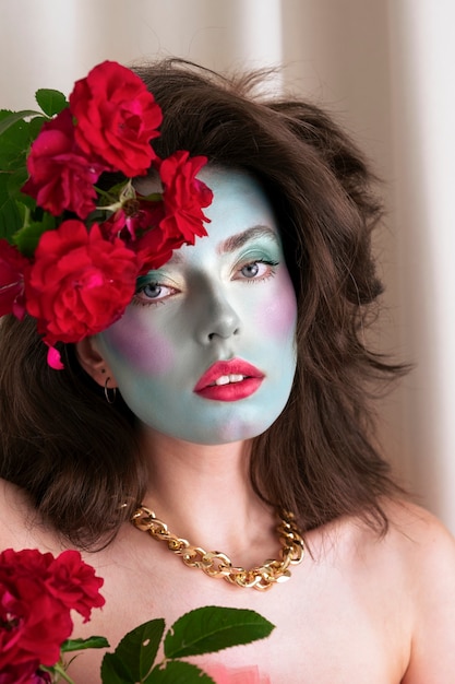 Free photo portrait of beautiful young woman with face paint and flowers