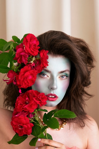 Free photo portrait of beautiful young woman with face paint and flowers