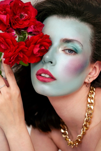 Free photo portrait of beautiful young woman with face paint and flowers