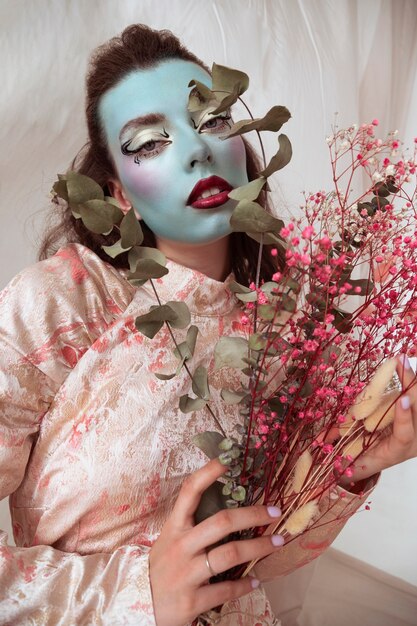 Portrait of beautiful young woman with face paint and flowers