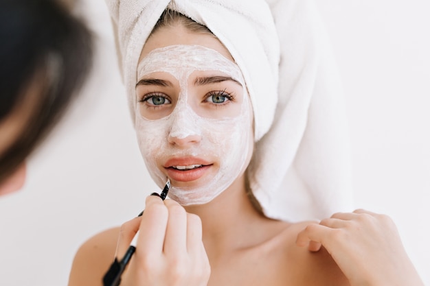 Free photo portrait of beautiful young woman with towels after take bath make cosmetic mask on her face.