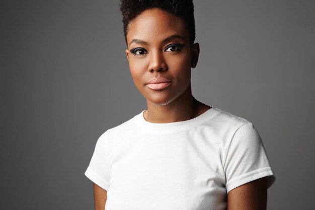 Portrait of black woman with short haircut with drama makeup eyes in grey background