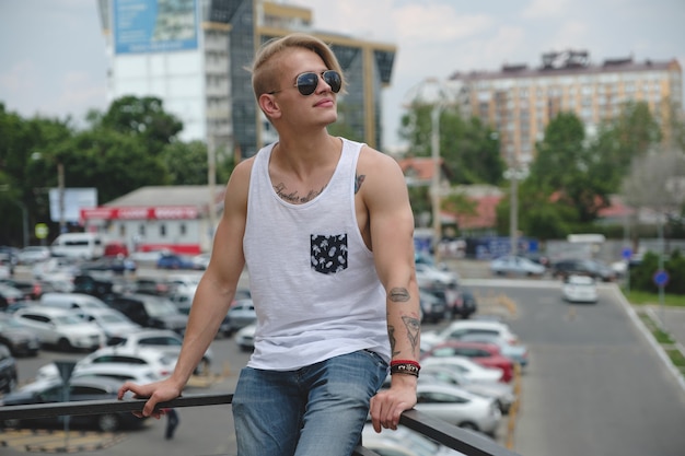 Portrait blonde hipster boy with tattoos and stylish hair