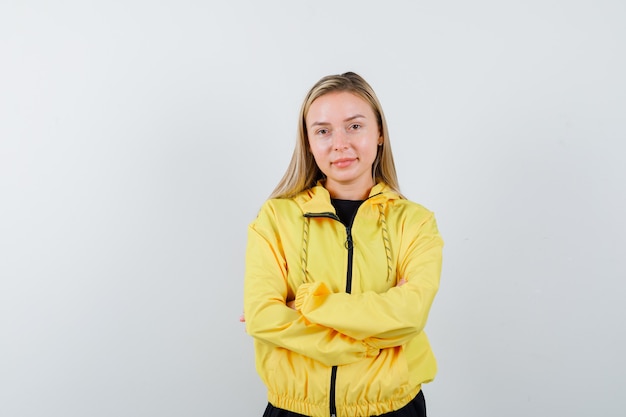 Free Photo portrait of blonde lady holding arms folded in tracksuit and looking confident front view