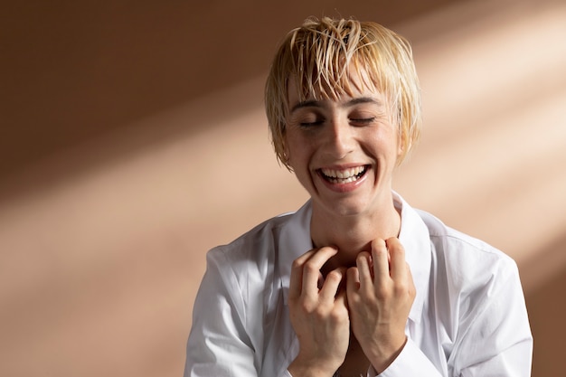 Free photo portrait of blonde short-haired woman posing in a white shirt