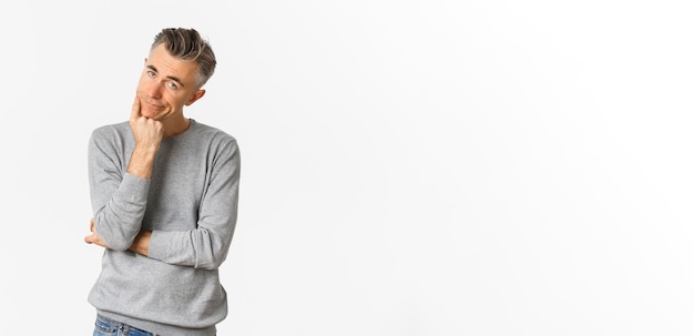 Free photo portrait of bored and unamused middleaged man in grey sweater leaning on hand and looking at camera