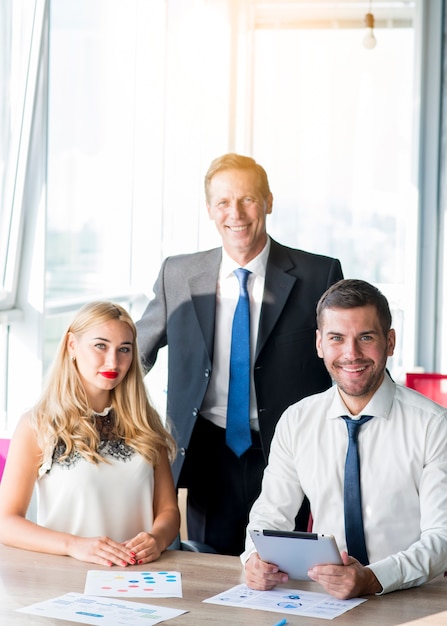 Free photo portrait of boss with his two colleagues at workplace in the office