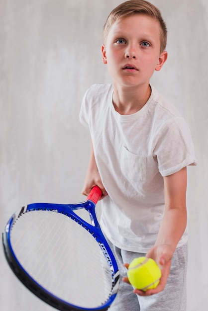 Portrait of a boy playing with racket and ball