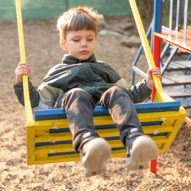 Free photo portrait boy in swing