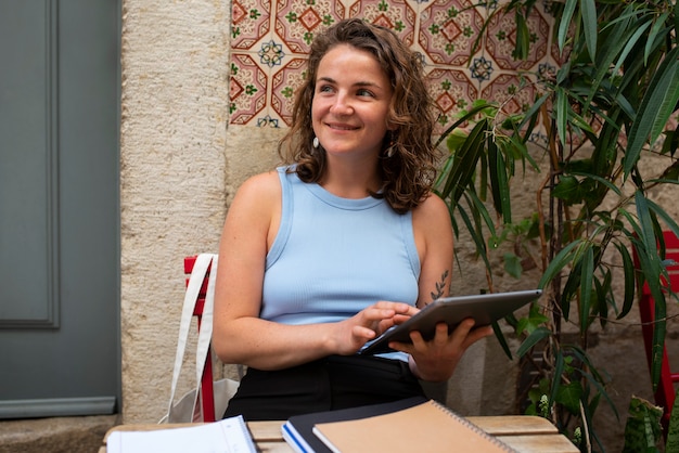 Portrait of braless woman outdoors with tablet at cafe