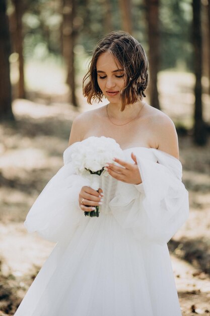 Portrait of bride in wedding dress in forest