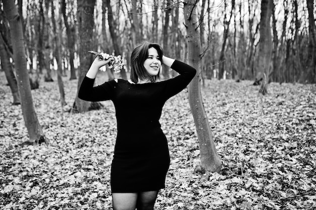 Portrait of brunette girl in black dress at spring wood