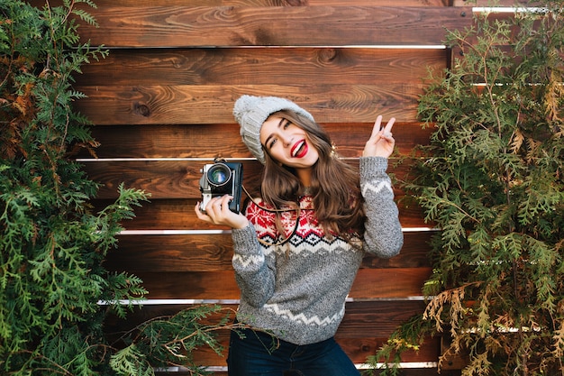 Free Photo portrait brunette girl with long hair in warm sweater having fun with camera on wooden  outdoor.