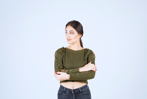 Free photo portrait of brunette woman standing and looking at somehwere on white background.