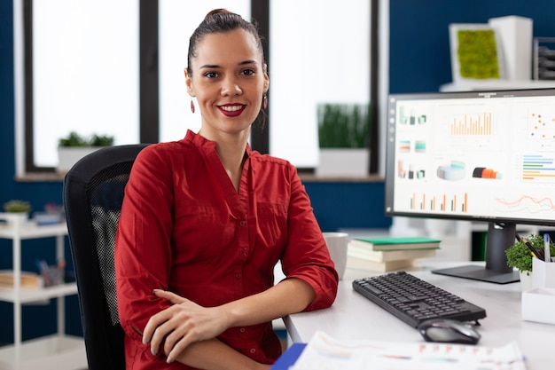 Portrait of business woman in corporate office sitting at desk