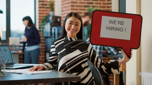 Free photo portrait of business woman holding speech bubble to show job offer, advertising hiring and recruitment. female employee using text message board to give business career opportunity.