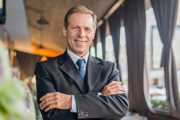 Portrait of a businessman with folded arms looking at camera