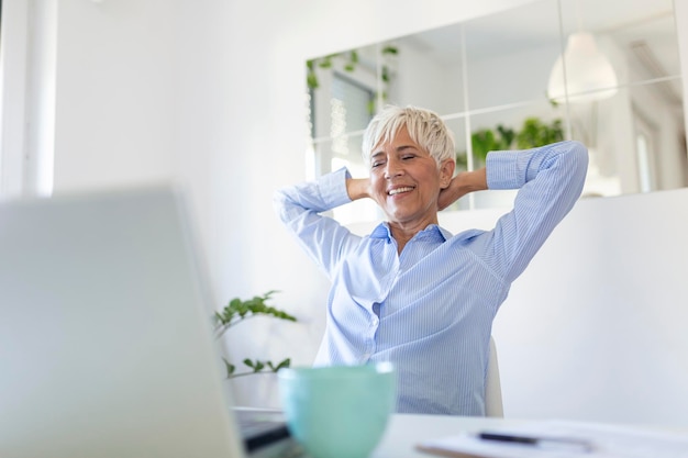 Portrait of casual woman using her laptop while sitting home office and working An attractive middle aged businesswoman sitting in front of laptop and managing her small business from home