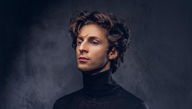 Portrait of a charismatic sensual male in black sweater. Creative personality.