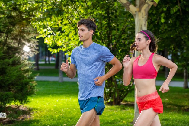 Portrait of cheerful caucasian couple running outdoors. Sport family