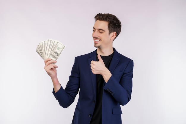 Portrait of a cheerful man holding dollar bills over white background