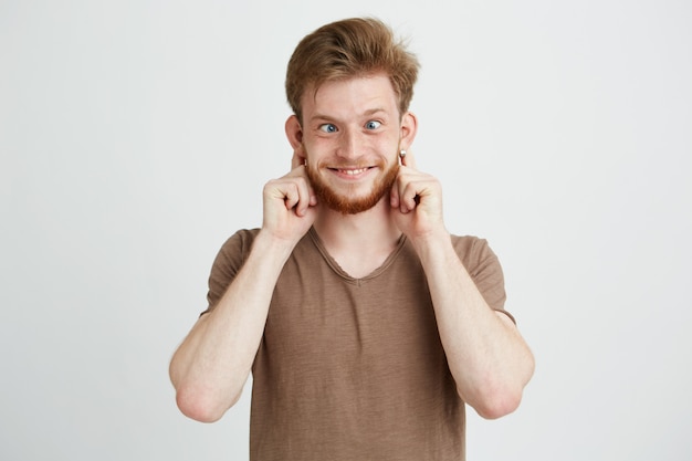 Portrait of cheerful merry young man making funny face fooling.