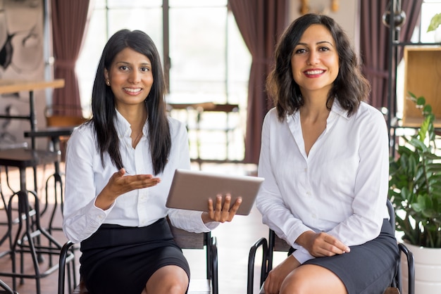 Free photo portrait of cheerful multiethnic female colleagues meeting in lounge room.