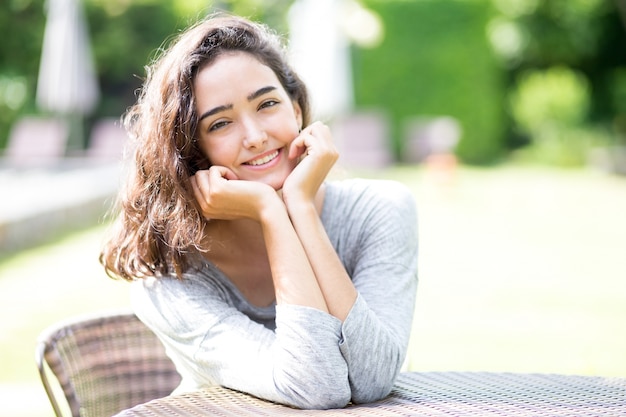 Free photo portrait of cheerful teenage girl sitting at table